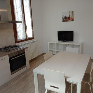a white kitchen with a white table and chairs at SANTA MARIA HOUSE in Empoli