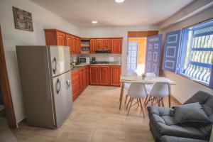 a kitchen with a stainless steel refrigerator and a table at Apartahotel Villa carolina 1 in Jericó
