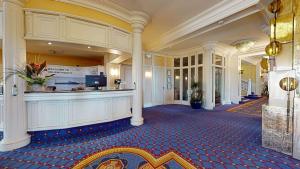 a lobby with a bar in the middle of a building at Bournemouth Carlton Hotel, BW Signature Collection in Bournemouth