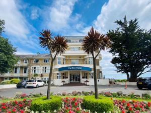 a large white building with palm trees in front of it at Bournemouth Carlton Hotel, BW Signature Collection in Bournemouth
