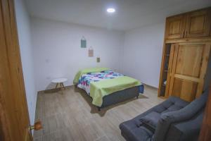 1 dormitorio con cama y sofá en Apartahotel Villa carolina 1 en Jericó
