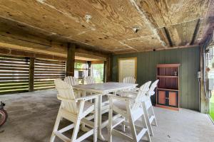 a dining room with a table and white chairs at Tree Frog KDH920 in Kill Devil Hills