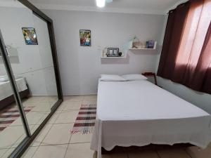 a bedroom with a white bed in a room at Apartamento próx ao centro Londrina in Londrina