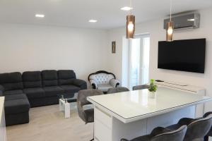un soggiorno con divano e TV di Apartman Milena a Solin (Salona)