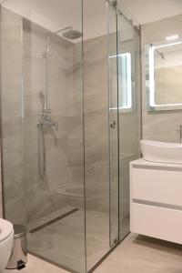 un bagno con cabina doccia in vetro e lavandino di Apartman Milena a Solin (Salona)