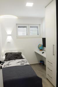 una camera con letto, scrivania e finestre di Apartman Milena a Solin (Salona)