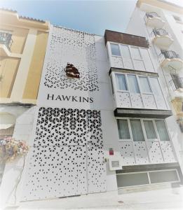 Ein weißes Gebäude mit einem Schild, das Hawkins liest. in der Unterkunft Coqueto apartamento nuevo en pleno centro de Algeciras BB in Algeciras