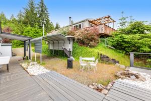 a backyard with a wooden deck with a table and chairs at Hoodsport Hideaway in Hoodsport