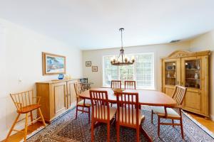 a dining room with a wooden table and chairs at Spinnaker Trail in Orleans