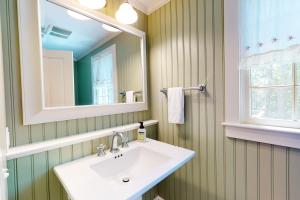 a bathroom with a sink and a mirror at Spinnaker Trail in Orleans +39 photos