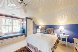 a bedroom with blue walls and a bed and a window at Spinnaker Trail in Orleans