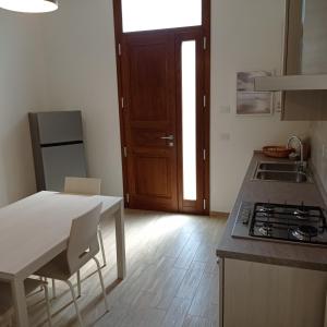 a kitchen with a stove and a table and a door at SANTA MARIA HOUSE in Empoli