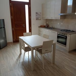 a kitchen with a white table and chairs in it at SANTA MARIA HOUSE in Empoli
