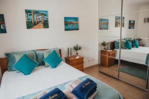 a bedroom with two beds and a mirror at Villa Tumbine in Cascais
