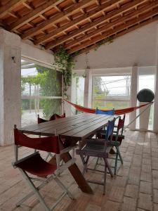 a wooden table with chairs and a hammock in a room at Monte da Casa Branca by Hi Alentejo in São Bartolomeu da Serra