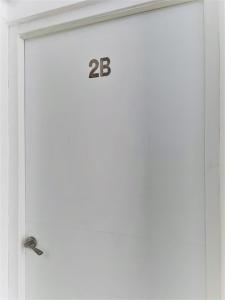 a white door with the number on it at Suite by Hawkins Exterior 2B in Algeciras