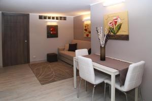 uma sala de estar com uma mesa e cadeiras e um sofá em Appartamento Dante em Catânia