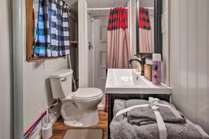 a small bathroom with a toilet and a sink at Lakefront Minocqua Cabin with Dock and Fire Pit! in Minocqua