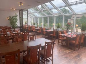 a restaurant with tables and chairs in a conservatory at Mansfelder Hof in Lutherstadt Eisleben