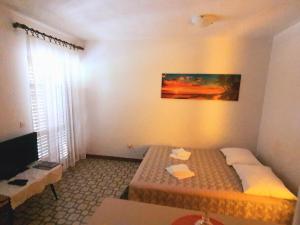 a small room with two beds and a television at Apartment Nadalina in Seget Vranjica