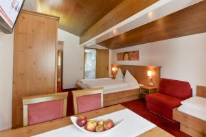 ein Schlafzimmer mit einem Bett und einer Obstschale auf einem Tisch in der Unterkunft Hotel Sonnblick in Wald am Arlberg