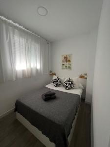 biała sypialnia z łóżkiem z czarnym kocem w obiekcie Suite by Hawkins Atico w mieście Algeciras