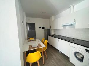 małą kuchnię ze stołem i żółtymi krzesłami w obiekcie Suite by Hawkins Atico w mieście Algeciras +8 zdjęć
