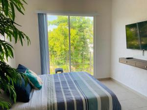 ein Schlafzimmer mit einem Bett und einem großen Fenster in der Unterkunft Franks House Luxury Apartment "Shared House" in Cancún