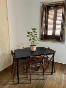 Vibo Apartment في فيبو فالينتيا: طاولة سوداء وكراسي عليها خزاف