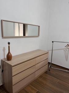 Vibo Apartment في فيبو فالينتيا: خزانة خشبية ومرآة فوقها
