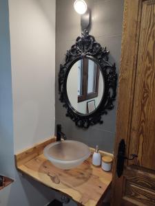 La salle de bains est pourvue d'un lavabo et d'un miroir sur un comptoir. dans l'établissement Casa Rural Casona Camino Pedraza - 4 Estrellas, à Arcones