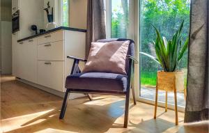 a chair in a kitchen with a plant next to a window at 3 Bedroom Cozy Home In Heinkenszand in Heinkensand