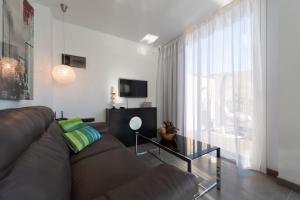 ein Wohnzimmer mit einem braunen Sofa und einem großen Fenster in der Unterkunft Holidays & Health in Finca Oasis - APART 6 in San Roque
