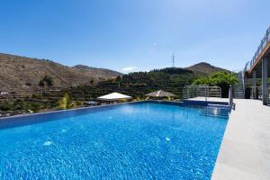 ein großer blauer Pool mit Bergen im Hintergrund in der Unterkunft Holidays & Health in Finca Oasis - APART 6 in San Roque