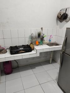 um balcão de cozinha com um fogão e um lavatório em Homestay Srikandi em Garut