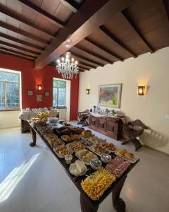 Pousada Cozy House في إتايبافا: طاولة طويلة مليئة بأنواع مختلفة من الطعام