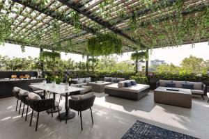 The Amsterdam-Luxury Plus by Viadora في مدينة ميكسيكو: فناء في الهواء الطلق مع طاولات وكراسي ونباتات