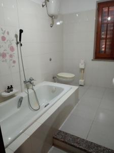 a white bathroom with a tub and a toilet at Il Salvatore in Masainas