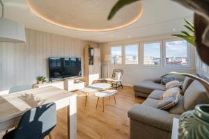 sala de estar con sofá y TV en Alfonso X - Apartamentos Burgos Deluxe en Burgos