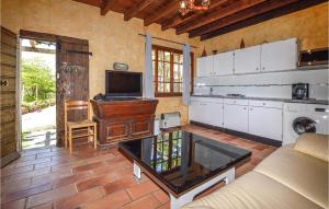 eine Küche mit einem Wohnzimmer mit einem Sofa und einem TV in der Unterkunft Lovely Home In Coti Chiavari With Wifi in Coti-Chiavari