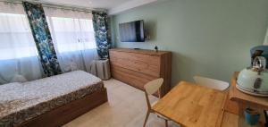 Studio confort, plages proche, wifi, 2 lits - FAME MARINA BAIE DES ANGES في فيلنوف لوبيه: غرفة نوم بسرير وطاولة وتلفزيون