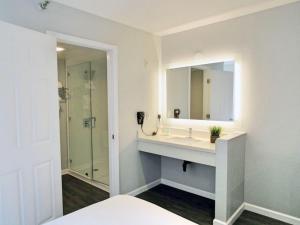 a bathroom with a sink and a shower at Capri Suites Anaheim in Anaheim