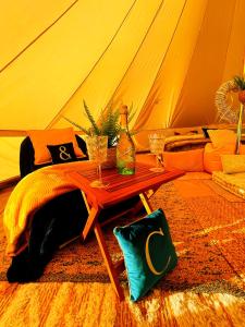 uma mesa com dois copos de vinho e uma tenda em CAYORETREAT LUXURY BELL TENT em Clodock