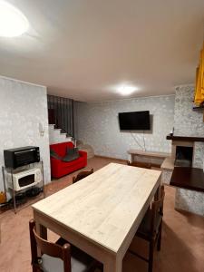un soggiorno con tavolo in legno e TV di holiday home a Vasto