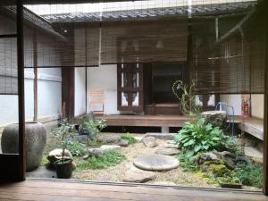 un jardín con rocas y plantas frente a un edificio en Veada, en Kioto