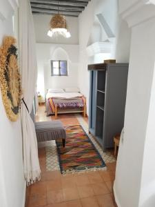 a bedroom with a bed and a bench in a room at RIAD MAROSKO in Essaouira
