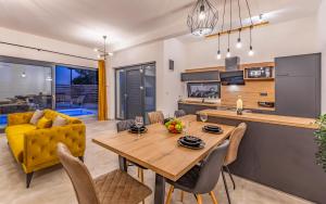a kitchen and living room with a wooden table and chairs at Villa RougeMarin - Marin with private pool in Medulin