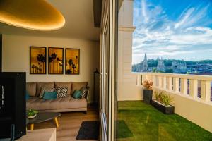 un soggiorno con divano e una grande finestra di Catedral - Apartamentos Burgos Deluxe a Burgos