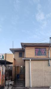 a house with a fence in front of it at Casa Enea Pudahuel in Santiago