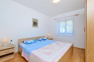 a bedroom with a bed with blue towels on it at Apartments with a parking space Cunski, Losinj - 7867 in Čunski